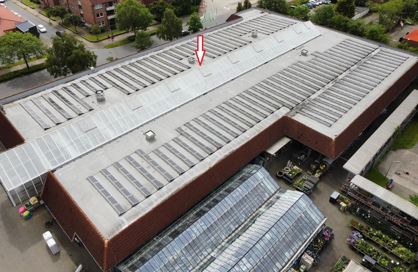 Dohnenaufnahme eines Baumarktes als Gesamtübersicht zur Bauzustandsanalyse im Bereich Dach und PV Anlage. Die Markierung zeigt wo ein Schaden ist, der detailliert im nächsten Bild dargestellt wird.